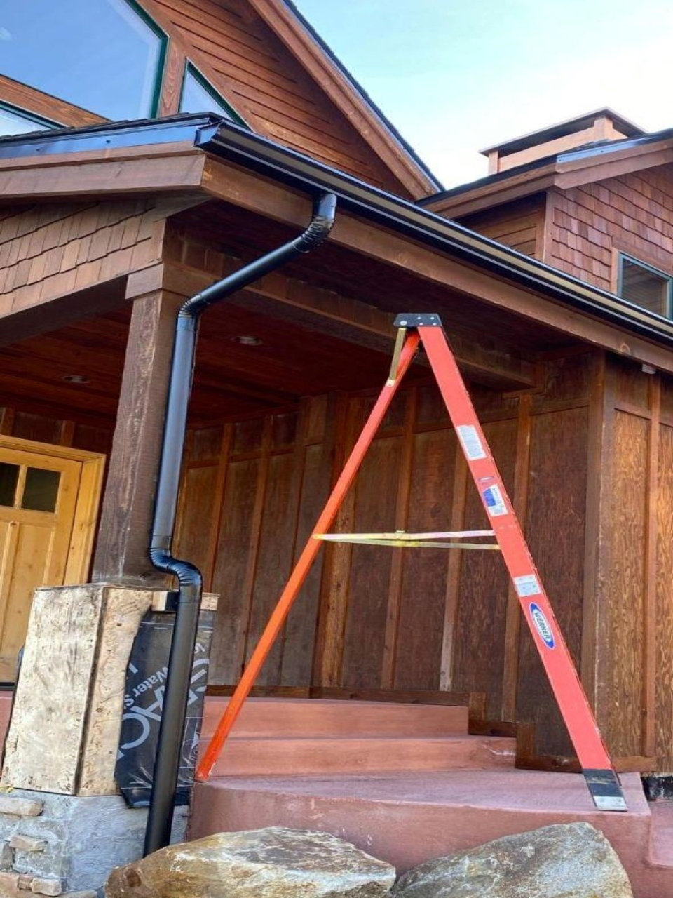White downspout and gutter installation on home